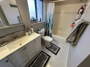 Full bathroom with shower / bath combination with curtain, vanity, and toilet