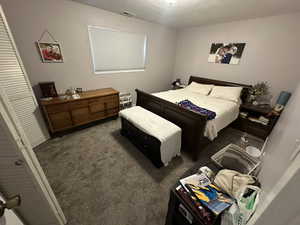 Bedroom with dark carpet and a closet