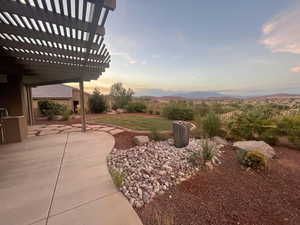 Yard at dusk featuring a mountain view, a patio area, and a pergola