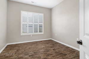 Empty room with dark hardwood / wood-style flooring