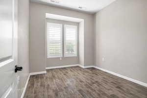 Empty room featuring dark wood-type flooring