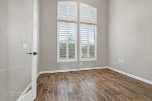 Unfurnished room featuring dark hardwood / wood-style floors