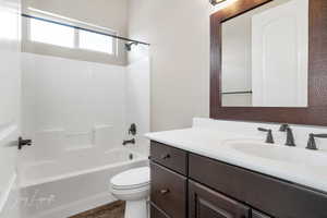 Full bathroom featuring vanity, toilet, wood-type flooring, and shower / bathing tub combination