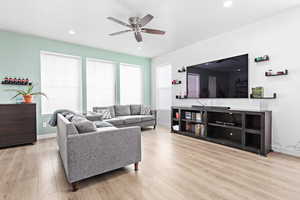 Living room featuring ceiling fan and light hardwood / wood-style floors