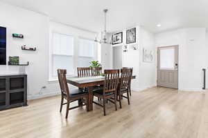 Dining area with a chandelier and light hardwood / wood-style flooring