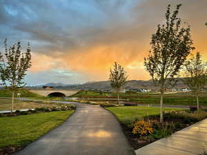 View of home's community with a water and mountain view and a yard