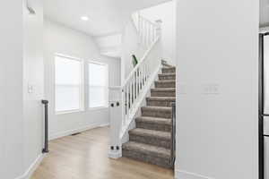 Staircase featuring hardwood / wood-style floors