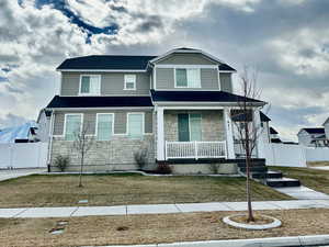 View of front of home with a porch and a front lawn