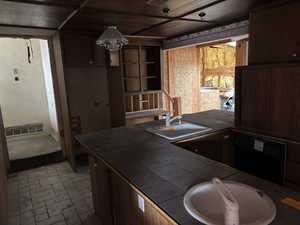 Kitchen with dishwasher, sink, and tile countertops