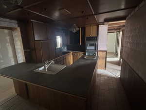 Kitchen with sink, double oven, and kitchen peninsula