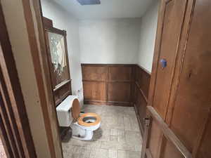 Bathroom with wood walls and toilet