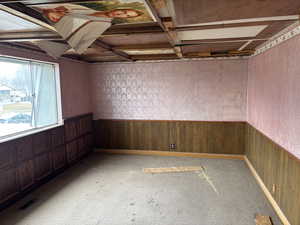 Unfurnished room with carpet and wood walls