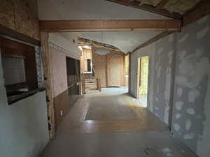 Hallway featuring vaulted ceiling with beams