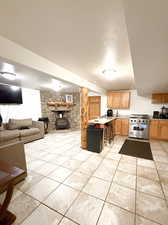 Kitchen with a wood stove, light tile patterned floors, and high end range