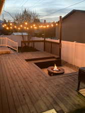 Deck at dusk featuring a fire pit