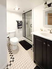 Bathroom with vanity, a textured ceiling, a shower with door, and toilet