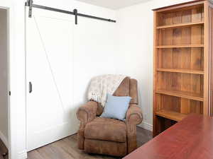 Living area featuring wood-type flooring and a barn door