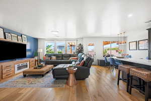 Living room with light hardwood / wood-style floors and a textured ceiling