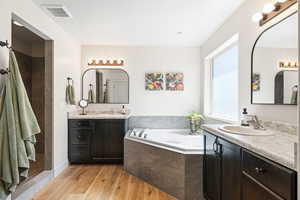 Bathroom with vanity, hardwood / wood-style floors, and separate shower and tub