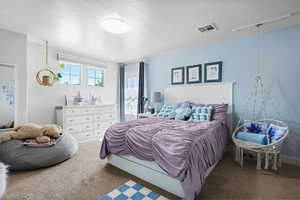 Bedroom featuring carpet floors and a textured ceiling