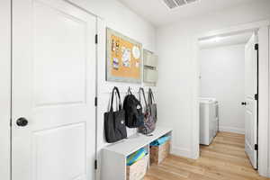 Mudroom featuring washer and clothes dryer and light hardwood / wood-style flooring