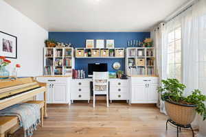 Home office with light hardwood / wood-style floors