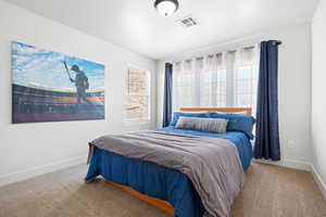 Bedroom featuring light carpet