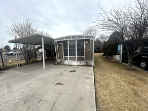 Exterior space featuring a lawn and a carport