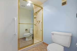 Bathroom with toilet and a shower with door