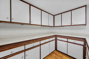 Kitchen featuring light hardwood / wood-style flooring and white cabinets