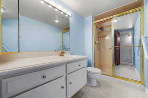 Bathroom with vanity, walk in shower, and toilet