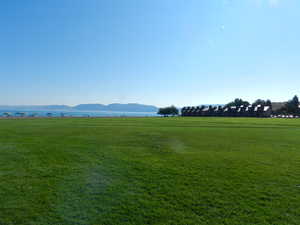 View of property's community with a mountain view, a lawn, and a rural view