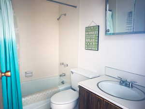 Full bathroom featuring vanity, shower / tub combo, and toilet