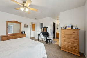 Carpeted bedroom with ceiling fan and connected bathroom