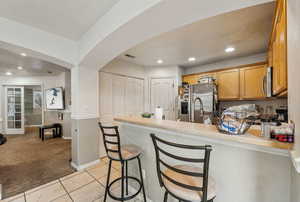 Kitchen with appliances with stainless steel finishes, a kitchen breakfast bar, kitchen peninsula,