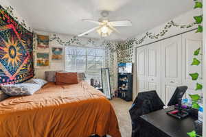 Bedroom with carpet floors, ceiling fan, and a closet