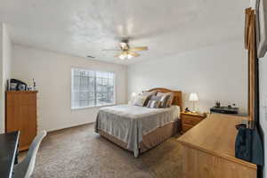 Bedroom with ceiling fan and dark carpet