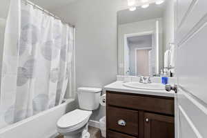 Full bathroom featuring shower / bath combination with curtain, vanity, and toilet