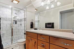 Bathroom with walk in shower, ornamental molding, toilet, and vanity