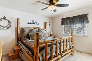 Carpeted bedroom with a textured ceiling and ceiling fan