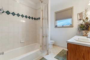 Full bathroom featuring vanity, shower / tub combo, and toilet