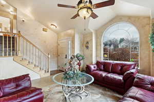 Living room featuring hardwood / wood-style flooring, lofted ceiling, and ceiling fan