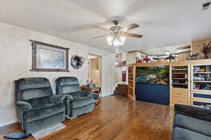 Living room featuring wood-type flooring and ceiling fan