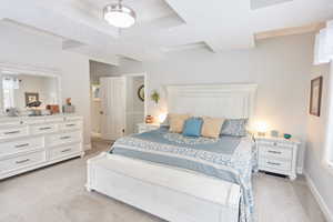 Bedroom featuring crown molding, light colored carpet, and a tray ceiling