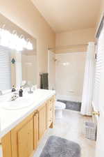 Casita - Full bathroom featuring toilet, vanity, shower / bathtub combination with curtain, and tile patterned flooring