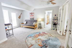 Living room featuring lofted ceiling, light colored carpet, ceiling fan, and french doors