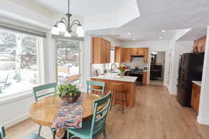 Dining area featuring light hardwood / wood-style flooring, sink, plenty of natural light, and a chandelier