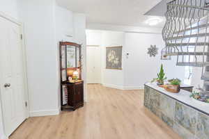 Corridor with light hardwood / wood-style flooring