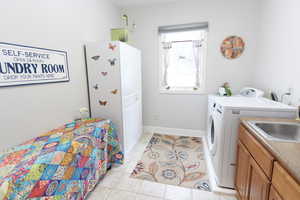 Tiled bedroom featuring sink and washing machine and clothes dryer