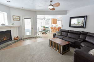 Living room featuring ceiling fan, light hardwood / wood-style floors, and a textured ceiling